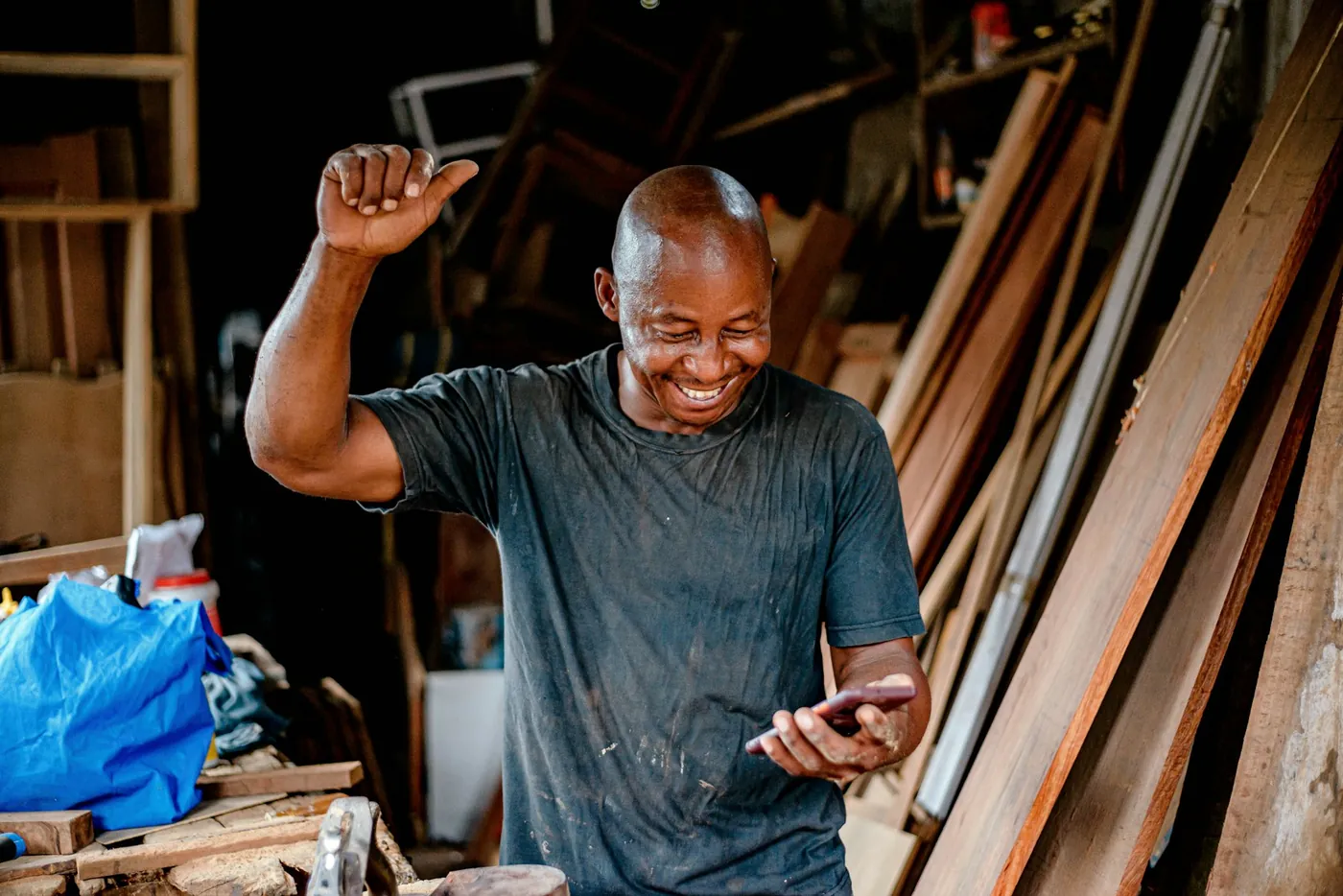 Hardware shop owner smiling at his phone